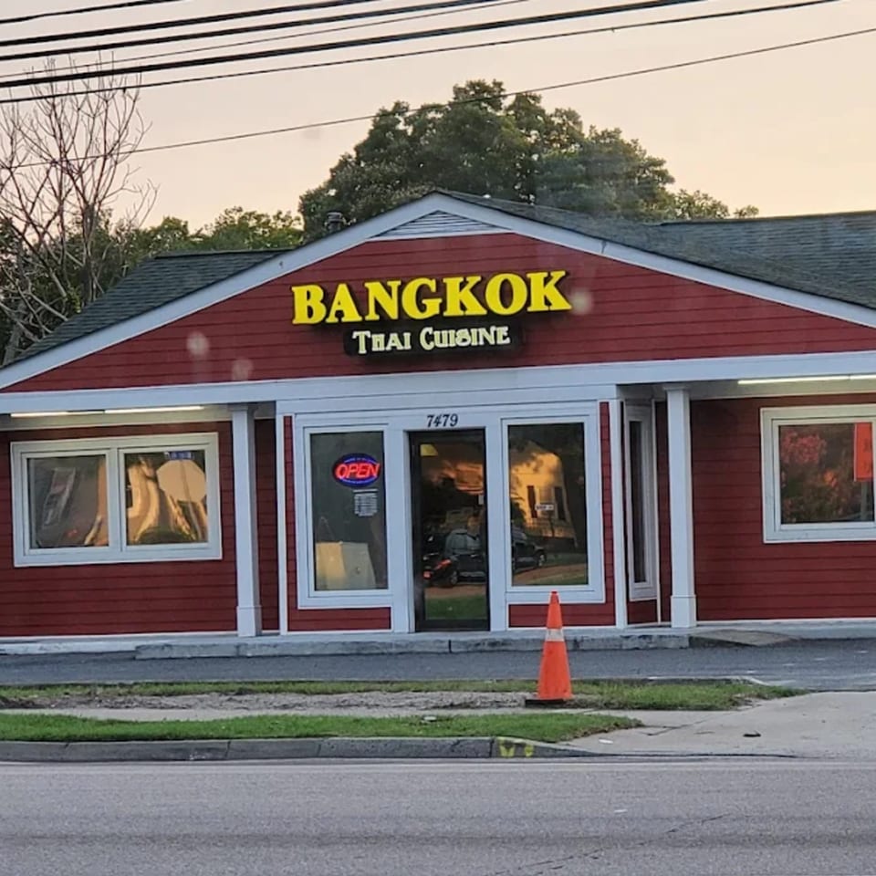 The exterior of Bangkok Thai Cuisine, a red building with a yellow sign, and an "OPEN" sign.