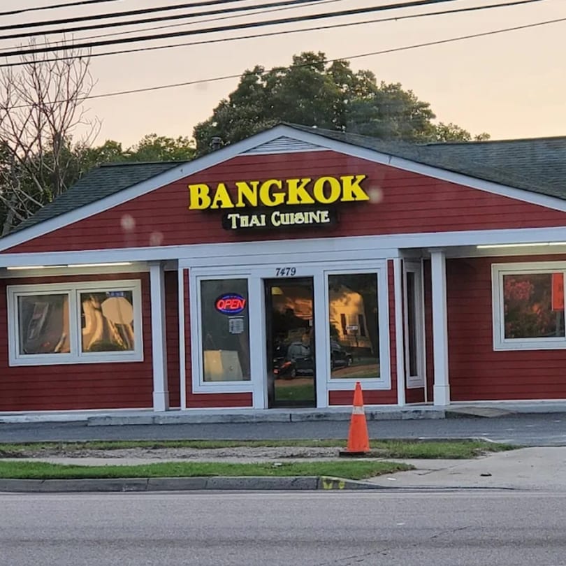 The exterior of Bangkok Thai Cuisine, a red building with a yellow sign, and an "OPEN" sign.